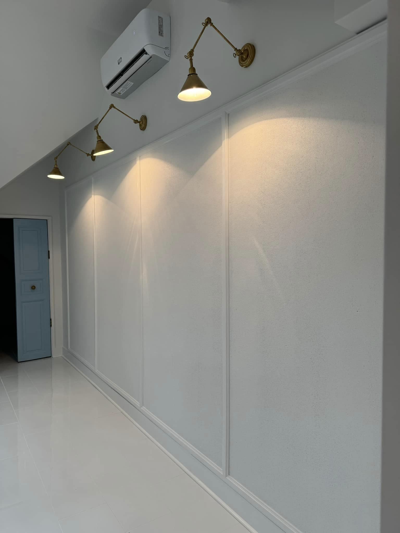Panelled wall with brass swing-arm sconces in a converted attic office, Chattanooga TN area