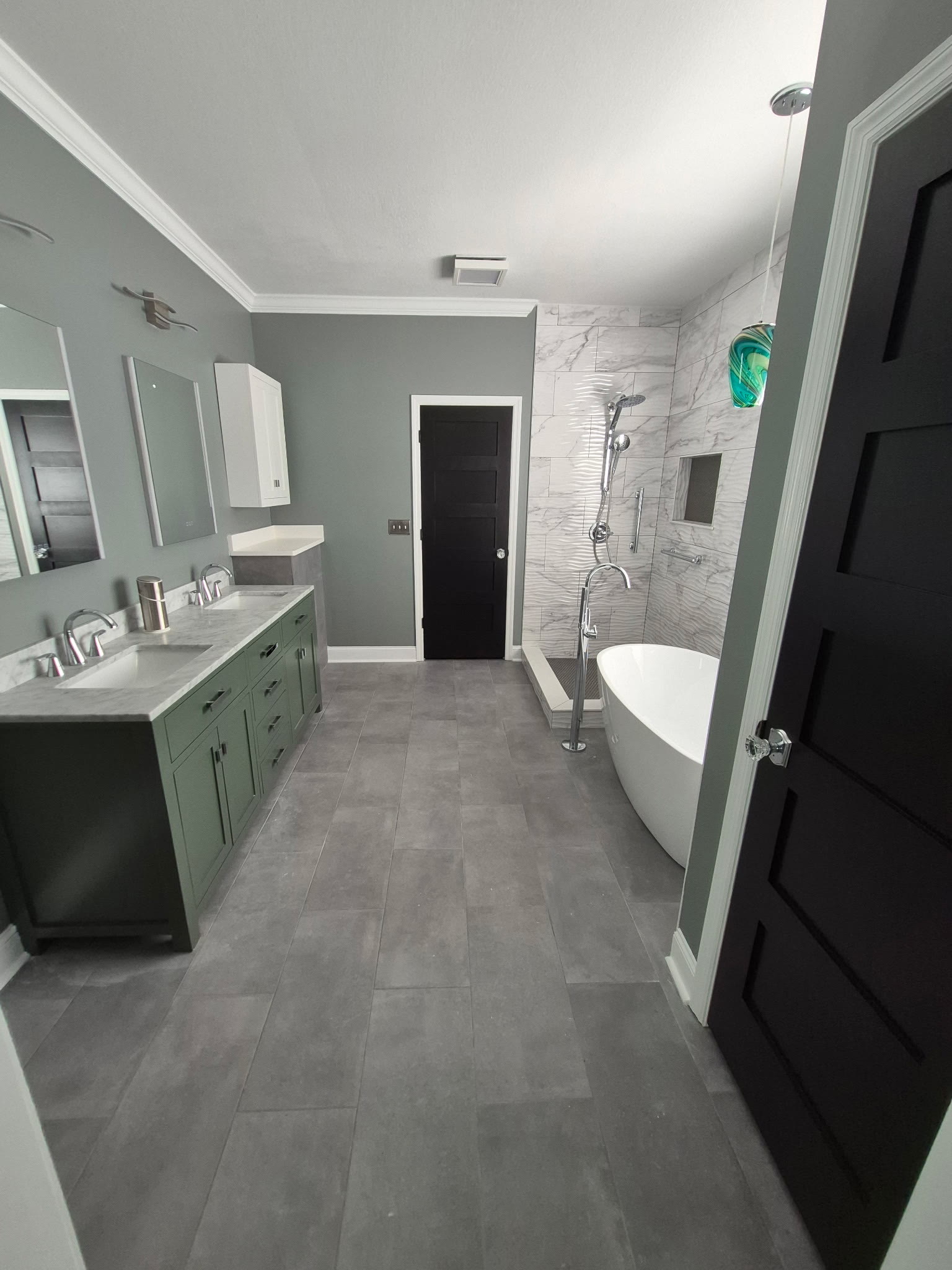 Master bathroom after remodel by Mountain City Pros &mdash; green double vanity, marble tile shower and freestanding tub, Chattanooga TN