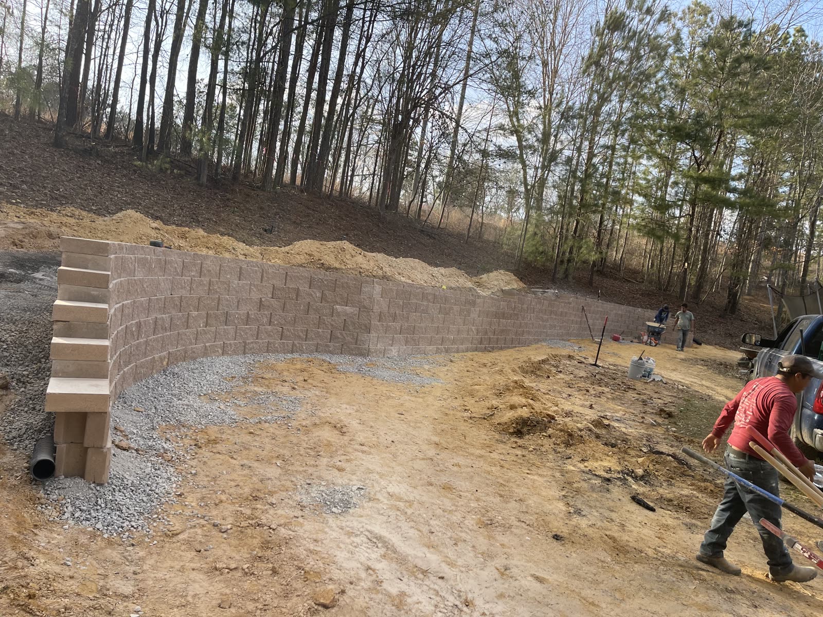 Block retaining wall being built into a hillside with gravel backfill and drainage, Chattanooga TN area