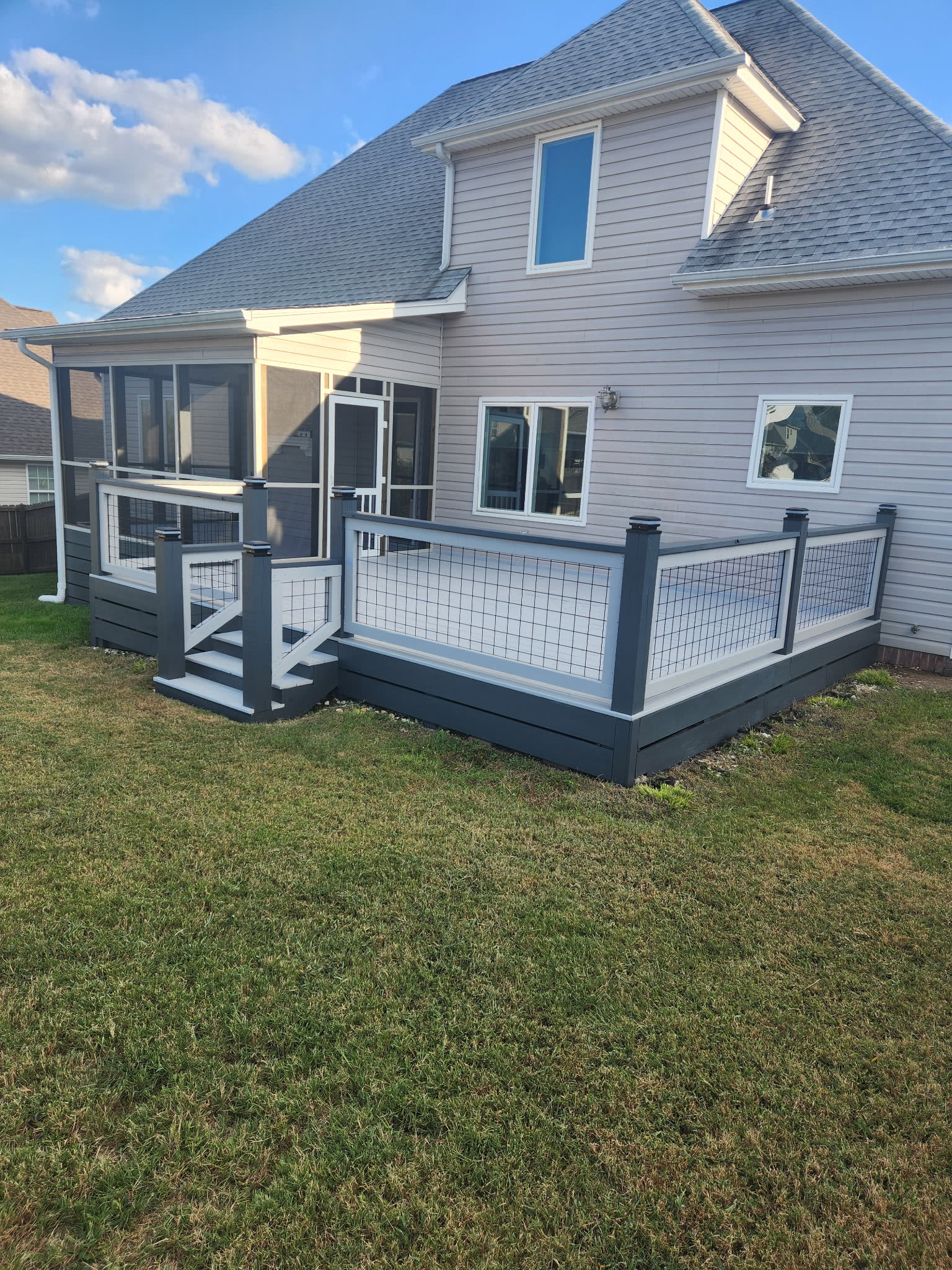 Grey and white composite deck with wire mesh railing beside a screened porch in Collegedale, TN