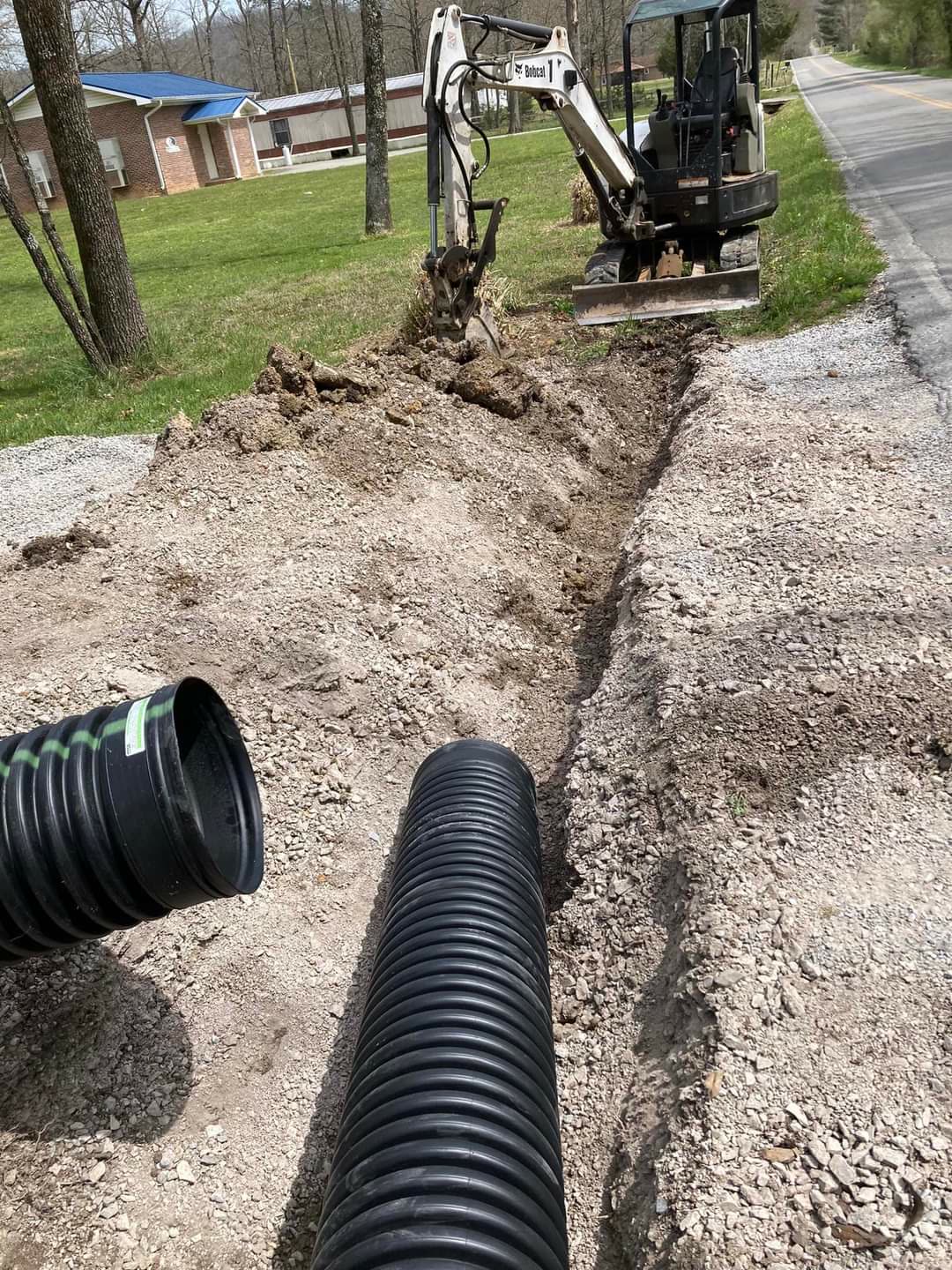 Drainage culvert pipe being installed with a Bobcat excavator, Chattanooga TN area