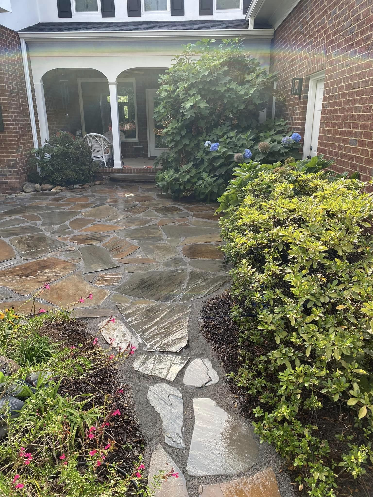 Hand-set flagstone courtyard patio and stepping-stone path with gravel joints at a brick home, Chattanooga TN area