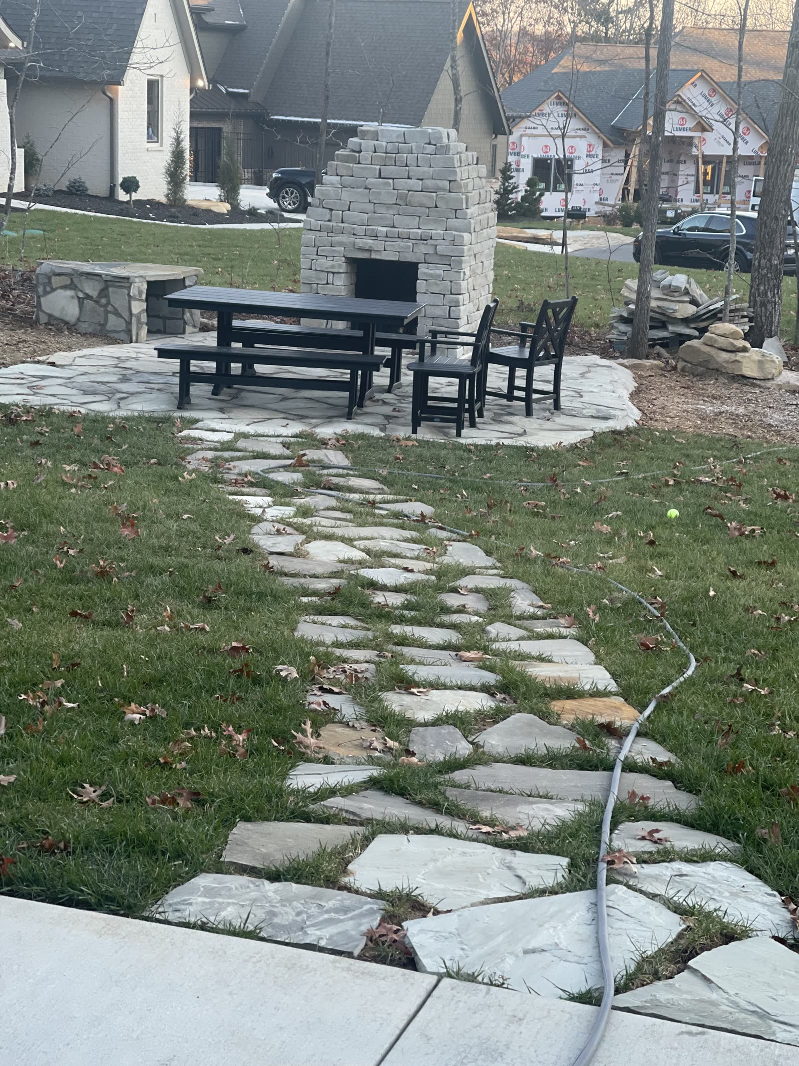 Flagstone stepping-stone path leading to a patio with outdoor seating and a stone fireplace on Signal Mountain, TN