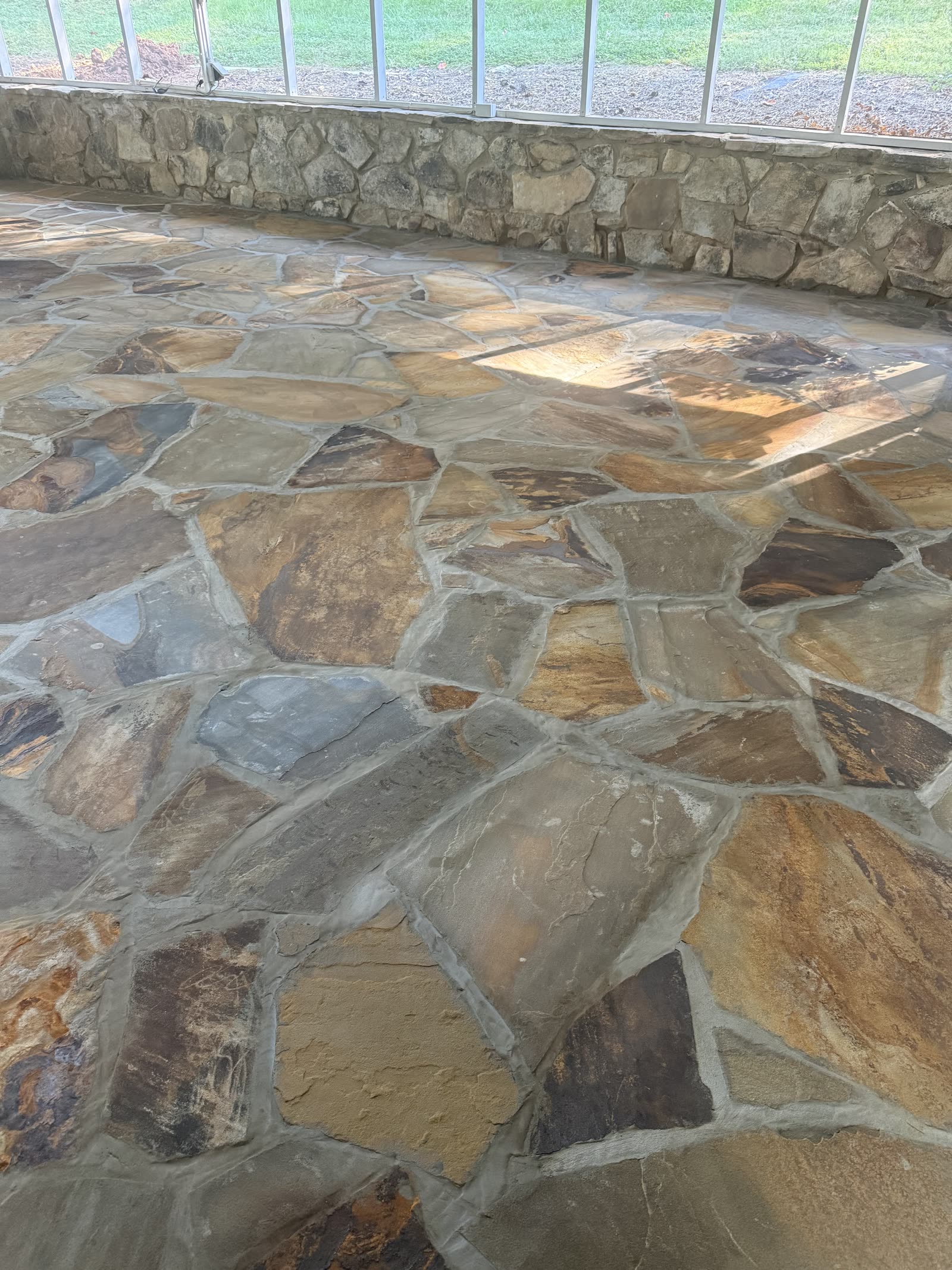 Flagstone floor laid on a screened porch above a natural stone knee wall, Chattanooga TN area