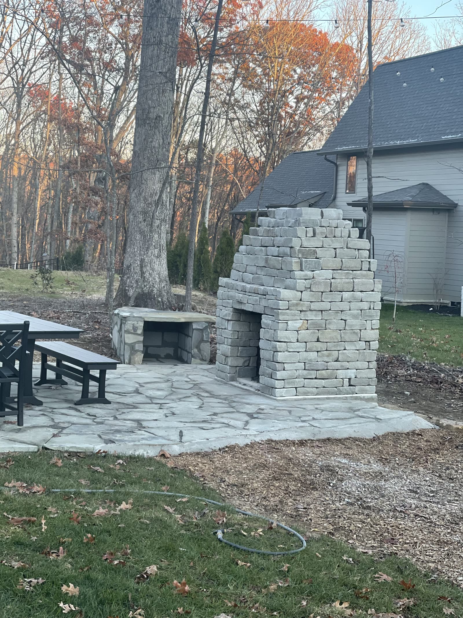 Stone outdoor fireplace and flagstone patio with outdoor seating on Signal Mountain, TN